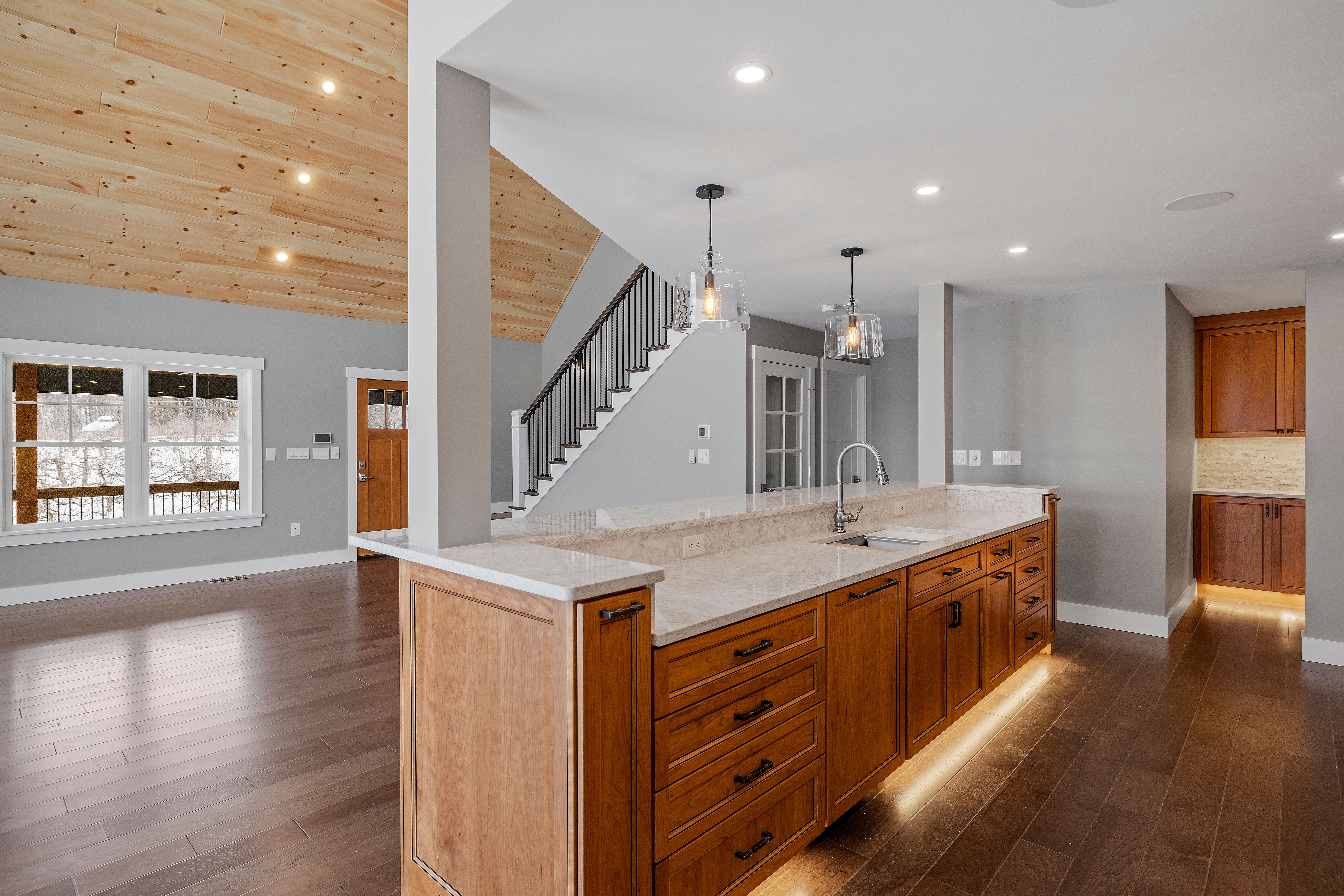 Bright home interior with wood stairs and kitchen